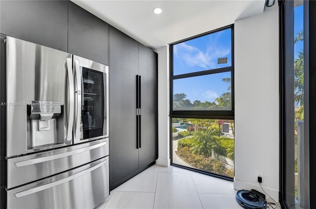 kitchen featuring light tile patterned floors, expansive windows, and stainless steel refrigerator with ice dispenser