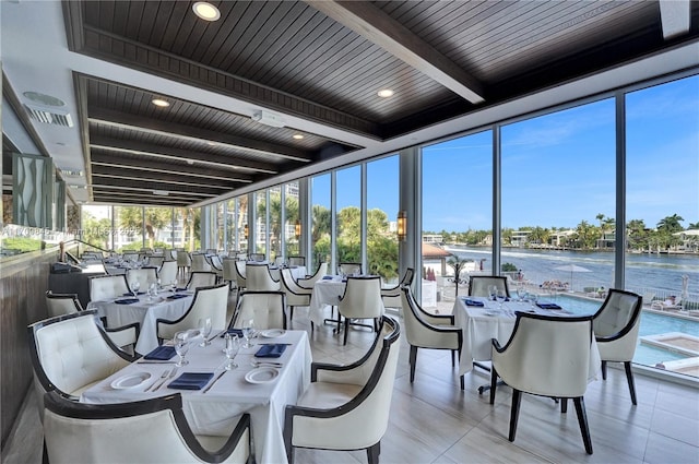 sunroom featuring a water view, wooden ceiling, and beamed ceiling