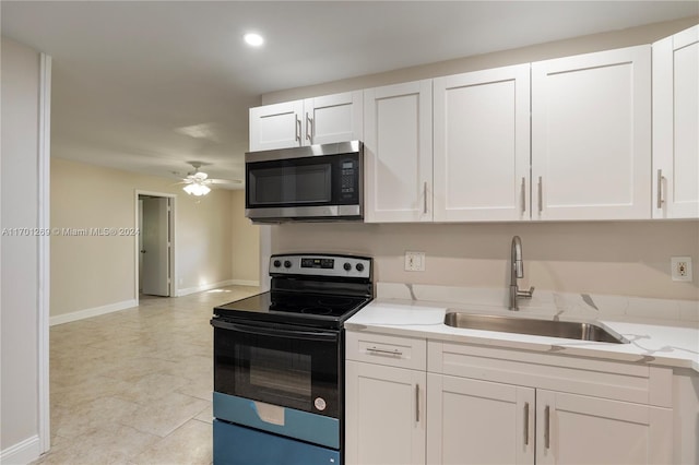 kitchen featuring sink, electric range, ceiling fan, light stone counters, and white cabinetry