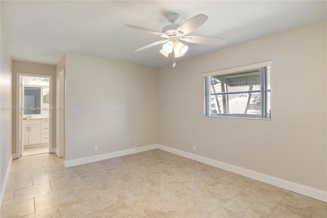 spare room featuring ceiling fan and light tile patterned floors