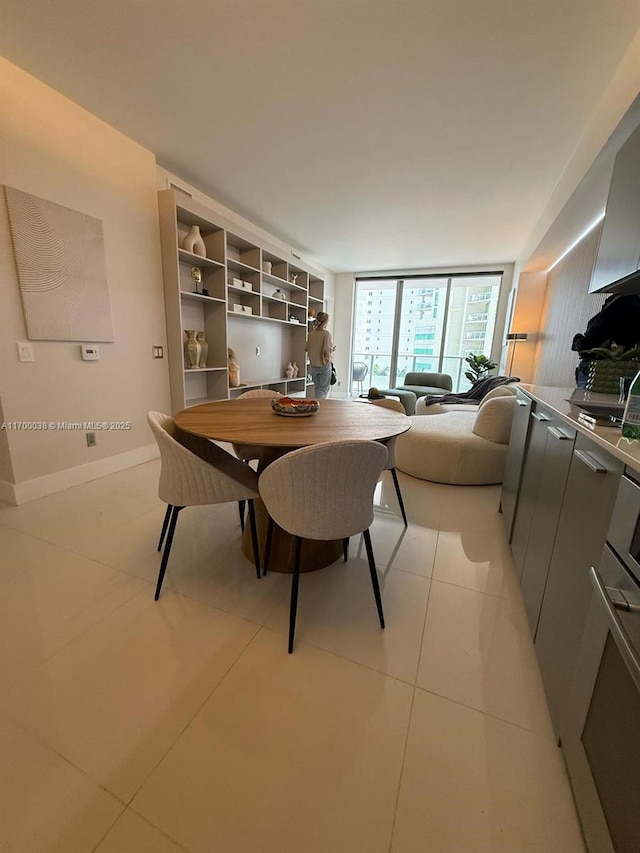 1300 Brickell Bay Dr Unit 604, Miami, FL 33131 - dining room with light tile patterned flooring, a wall of windows, and baseboards