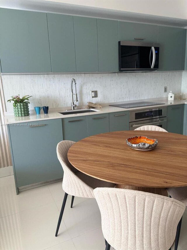1300 Brickell Bay Dr Unit 604, Miami, FL 33131 - kitchen featuring appliances with stainless steel finishes, a sink, tasteful backsplash, and light countertops