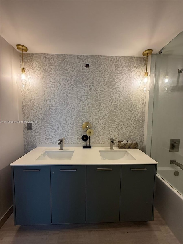 1300 Brickell Bay Dr Unit 604, Miami, FL 33131 - full bathroom featuring wallpapered walls, double vanity, shower / tub combination, and wood finished floors