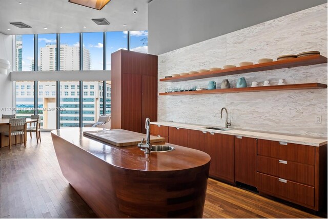 1300 Brickell Bay Dr Unit 604, Miami, FL 33131 - indoor wet bar featuring dark wood-style floors, floor to ceiling windows, decorative backsplash, a high ceiling, and a city view