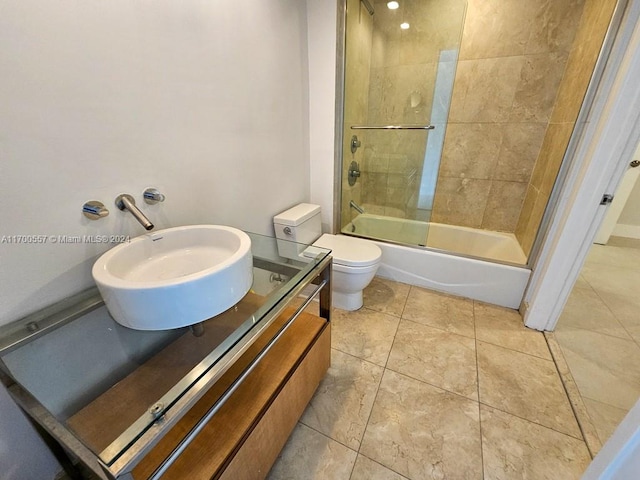 full bathroom featuring tile patterned floors, sink, enclosed tub / shower combo, and toilet