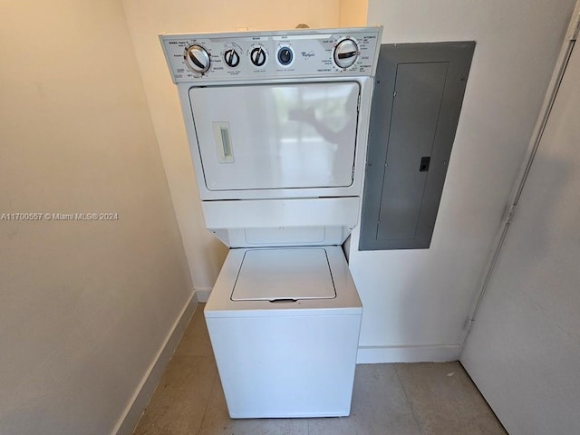 clothes washing area featuring electric panel and stacked washer and clothes dryer