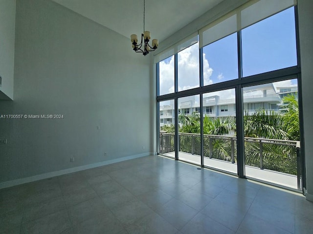 unfurnished room featuring a chandelier and a high ceiling