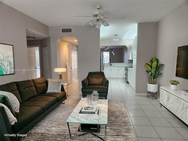 living room with sink, light tile patterned flooring, and ceiling fan