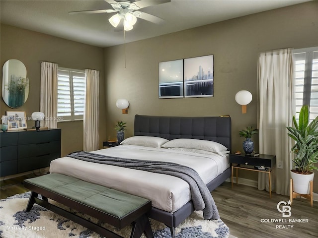 bedroom with ceiling fan, dark wood-type flooring, and multiple windows