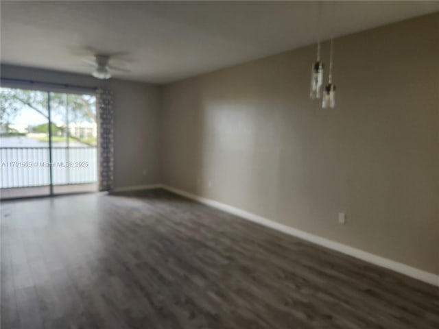 empty room featuring ceiling fan and dark wood-type flooring