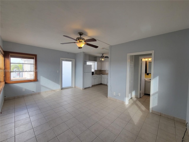 unfurnished living room with ceiling fan and light tile patterned floors