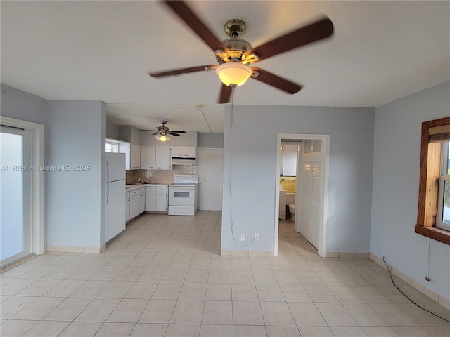 kitchen with white appliances, white cabinetry, a healthy amount of sunlight, and backsplash