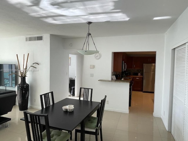 dining space featuring light tile patterned flooring