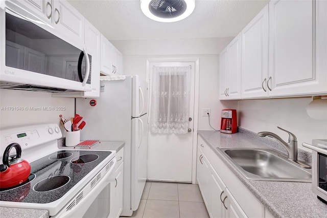 kitchen featuring light tile patterned flooring, sink, white cabinetry, a textured ceiling, and white appliances