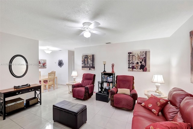 tiled living room featuring ceiling fan and a textured ceiling