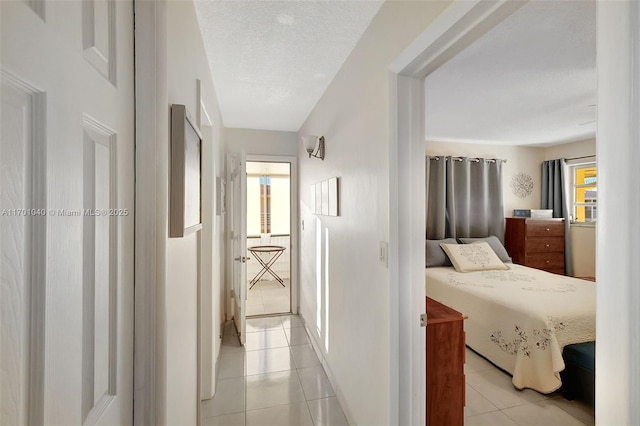 hallway featuring a textured ceiling and light tile patterned floors