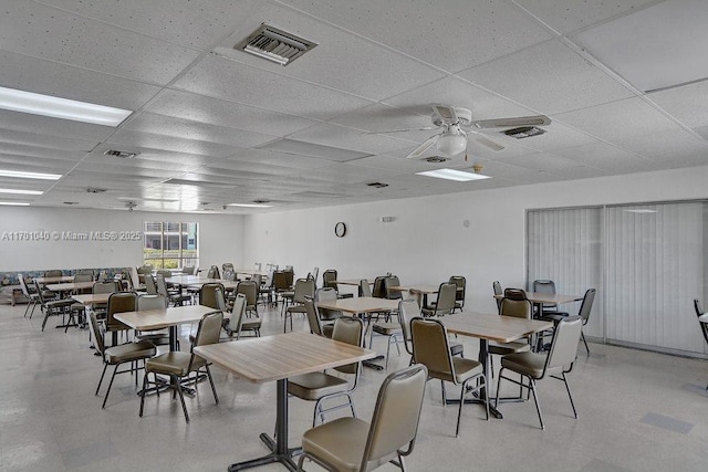 dining area with ceiling fan and a paneled ceiling