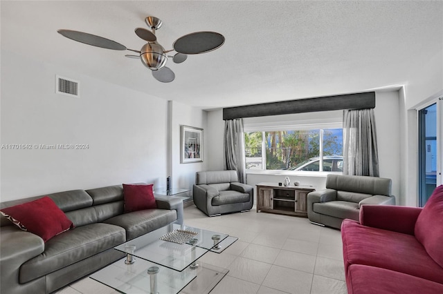 living room with ceiling fan and a textured ceiling