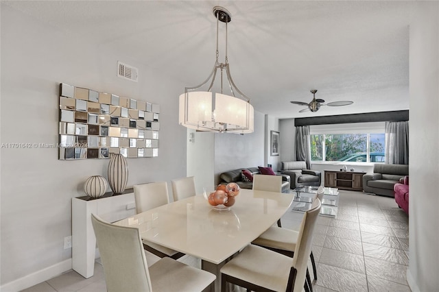 dining space featuring ceiling fan with notable chandelier