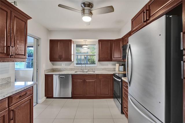 kitchen featuring plenty of natural light, sink, light stone counters, and stainless steel appliances