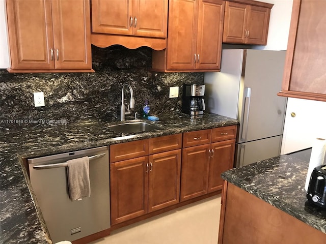 kitchen with dishwasher, backsplash, sink, dark stone countertops, and white fridge