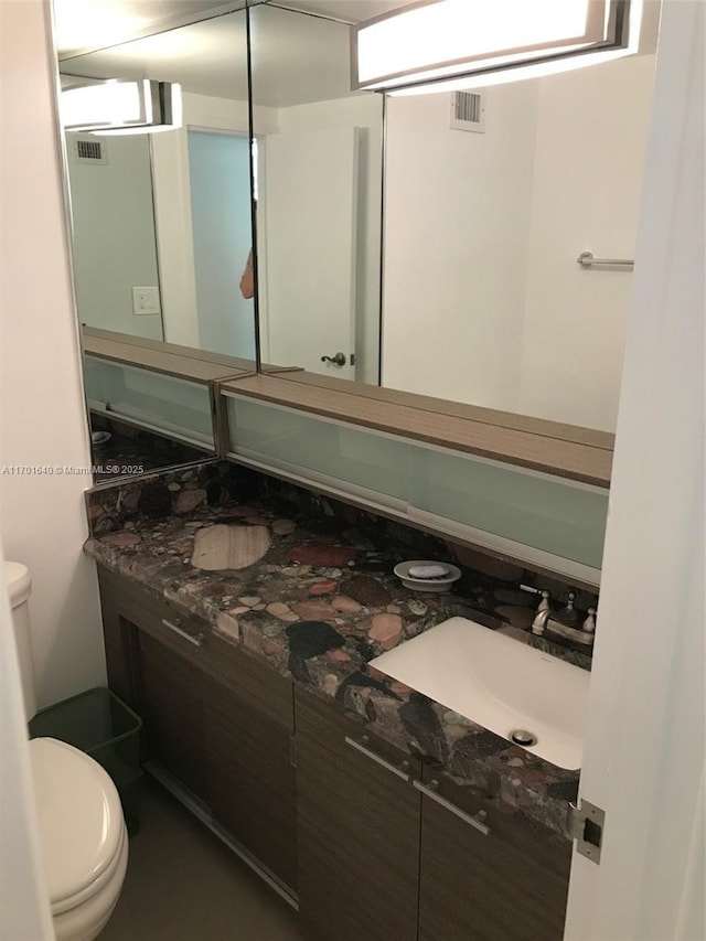 bathroom featuring vanity and toilet