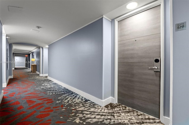 hall with baseboards and ornamental molding