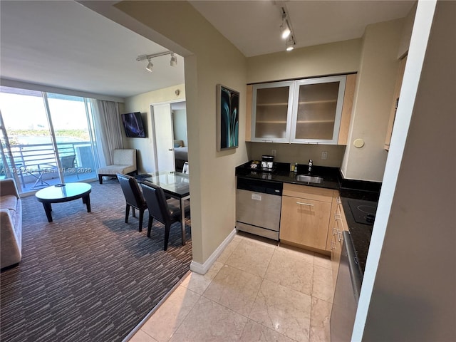 kitchen with open floor plan, stainless steel dishwasher, dark countertops, and rail lighting