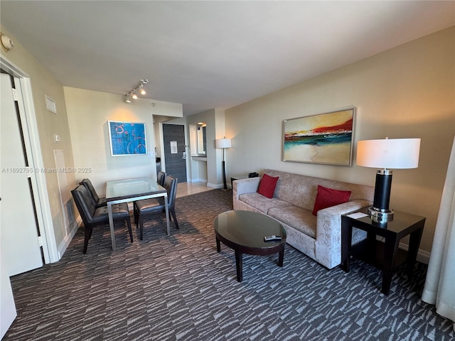 living area featuring dark colored carpet and rail lighting