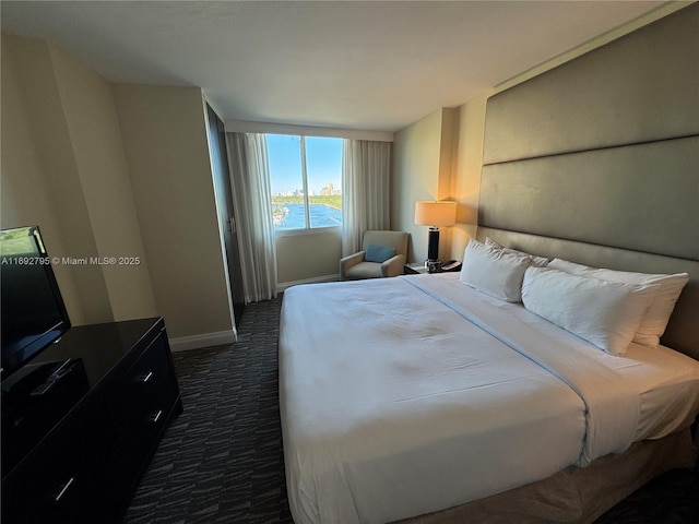 carpeted bedroom featuring a water view