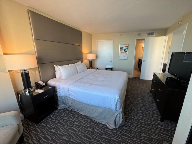 carpeted bedroom featuring visible vents