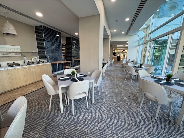 dining room featuring recessed lighting, carpet flooring, and a towering ceiling