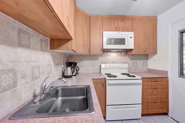 kitchen with decorative backsplash, white appliances, sink, and light tile patterned floors