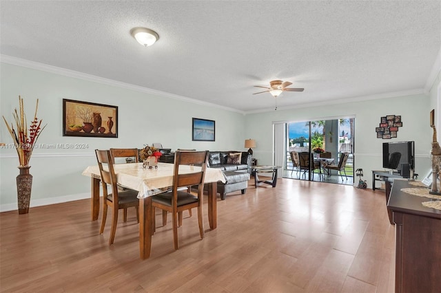 dining area with ceiling fan, light hardwood / wood-style floors, a textured ceiling, and ornamental molding