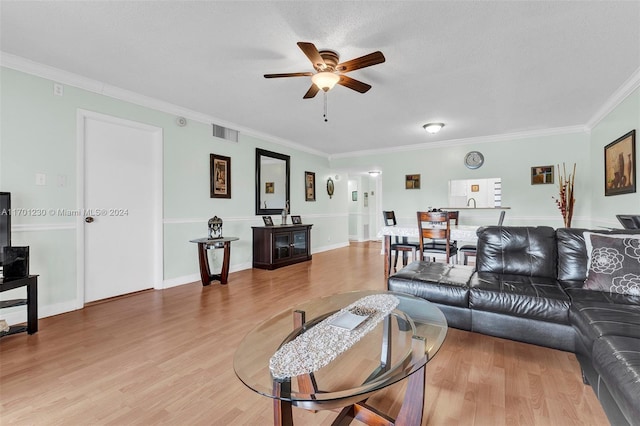 living room featuring ceiling fan, hardwood / wood-style floors, a textured ceiling, and ornamental molding