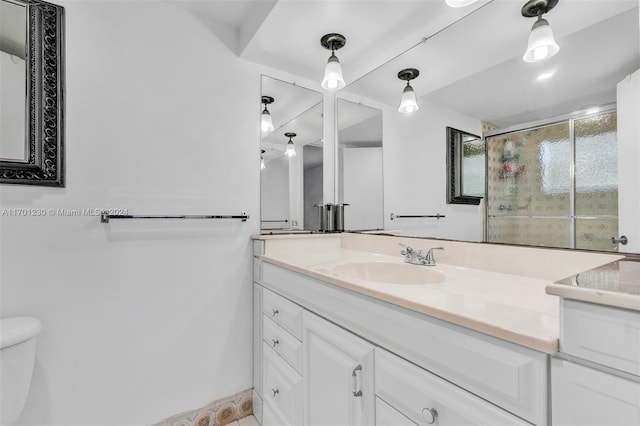 bathroom featuring vanity, a shower with shower door, and toilet