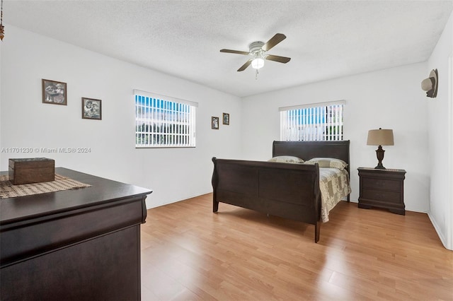 bedroom featuring ceiling fan, a textured ceiling, and light hardwood / wood-style flooring