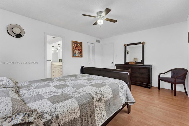 bedroom featuring ceiling fan, light hardwood / wood-style floors, a closet, and ensuite bath