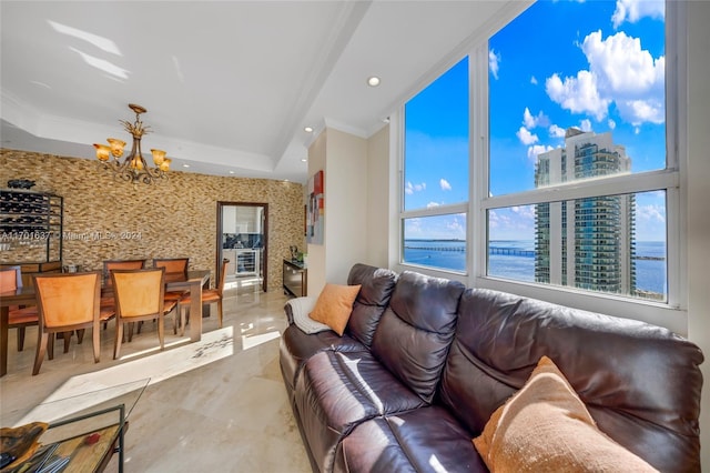 living room featuring a water view, ornamental molding, and a chandelier