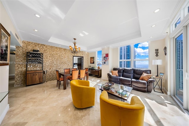 living room featuring a raised ceiling, crown molding, and a chandelier