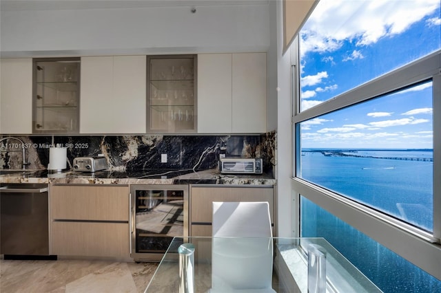 kitchen featuring modern cabinets, wine cooler, tasteful backsplash, and dark stone countertops