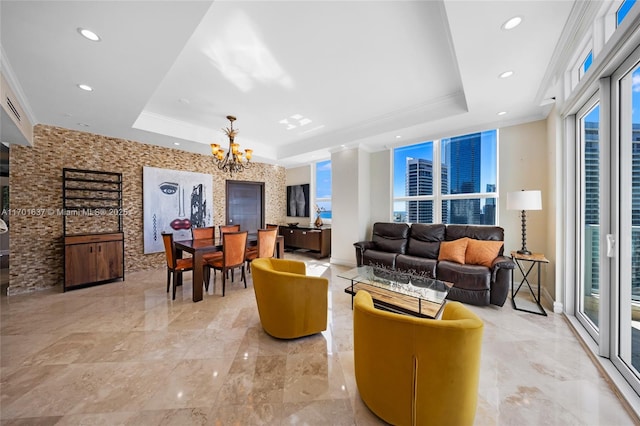 interior space with a tray ceiling, a chandelier, and ornamental molding