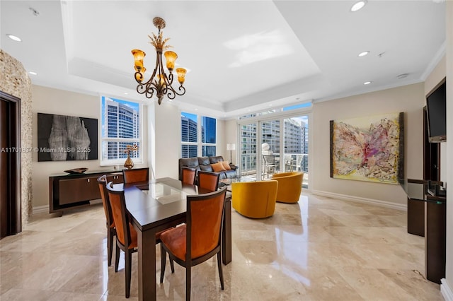 dining space featuring ornamental molding, a raised ceiling, and baseboards