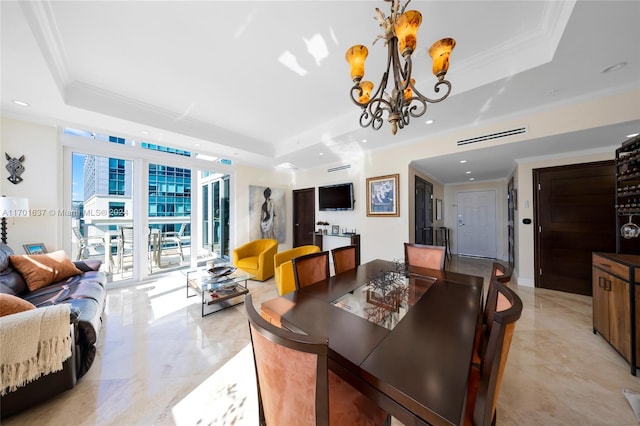 dining space with a tray ceiling, crown molding, and a notable chandelier