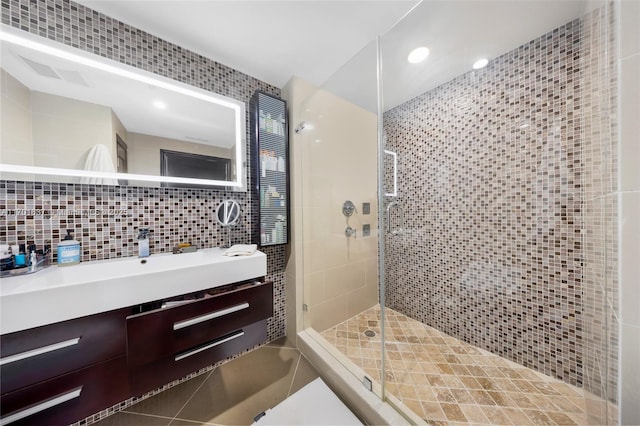 bathroom featuring tile walls, tasteful backsplash, recessed lighting, a shower stall, and vanity