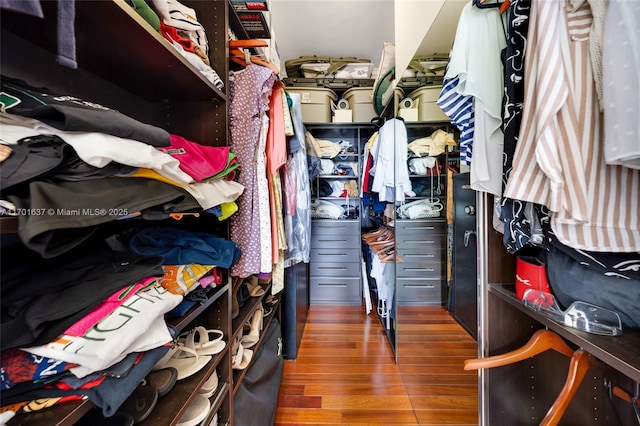 walk in closet with wood finished floors