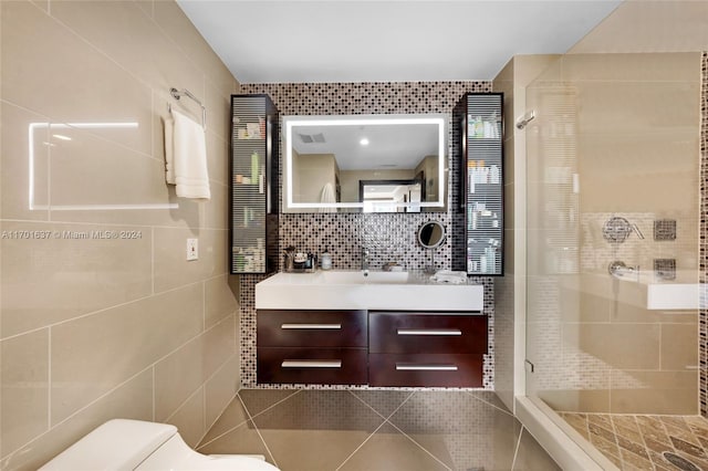 bathroom featuring decorative backsplash, vanity, a shower with door, tile walls, and toilet