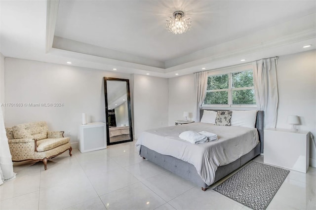 bedroom featuring light tile patterned floors, an inviting chandelier, and a raised ceiling