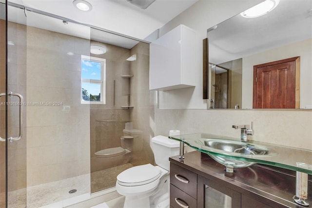 bathroom featuring tasteful backsplash, an enclosed shower, toilet, vanity, and tile walls