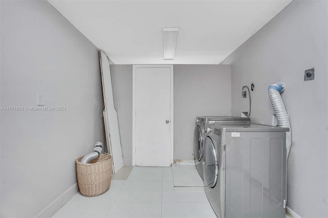 clothes washing area with light tile patterned floors and washing machine and dryer